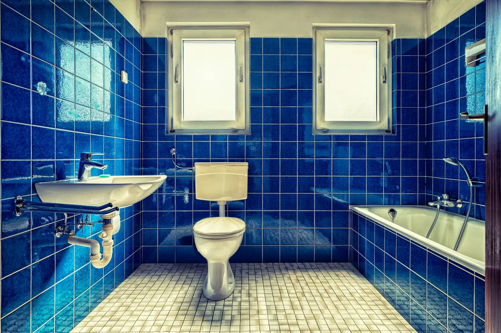 A dated bathroom with blue tile