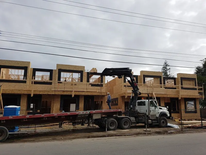Comark townhome row framed, crane truck delivering trusses